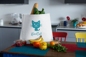 Cat-Themed shopping bag.  A blue cat on a white tote bag on a kitchen table.